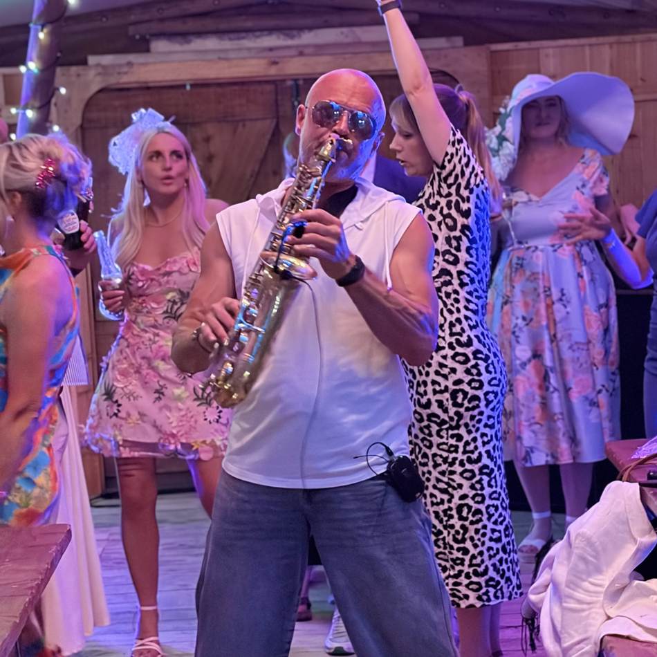 Paul Martyn playing saxophone among wedding guests