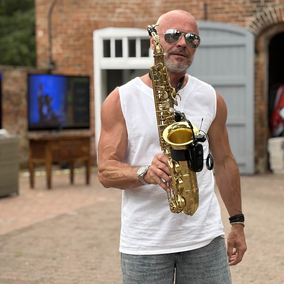 Paul Martyn playing saxophone outdoors at a courtyard venue